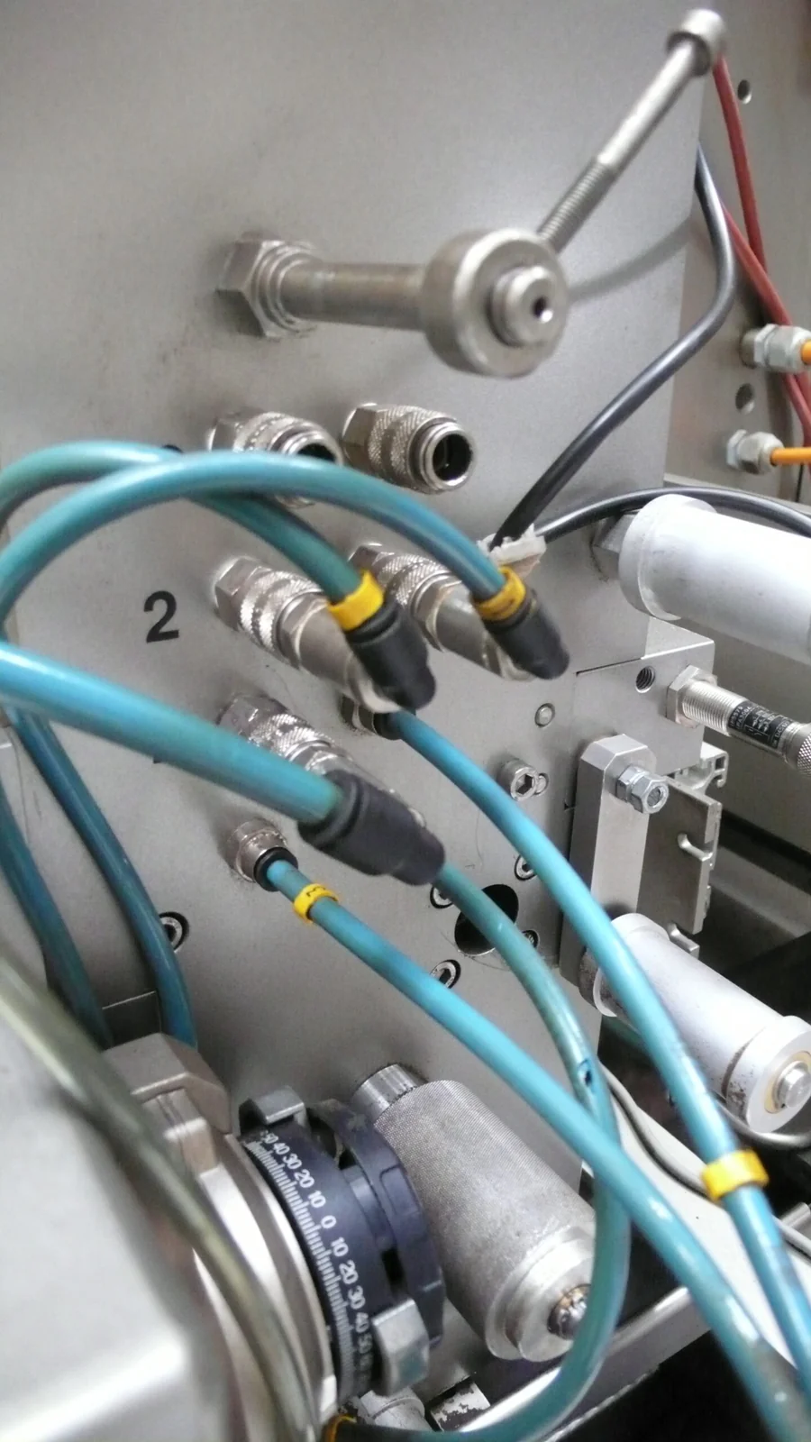 Genummerde aansluitingen met slangen op een productiemachine