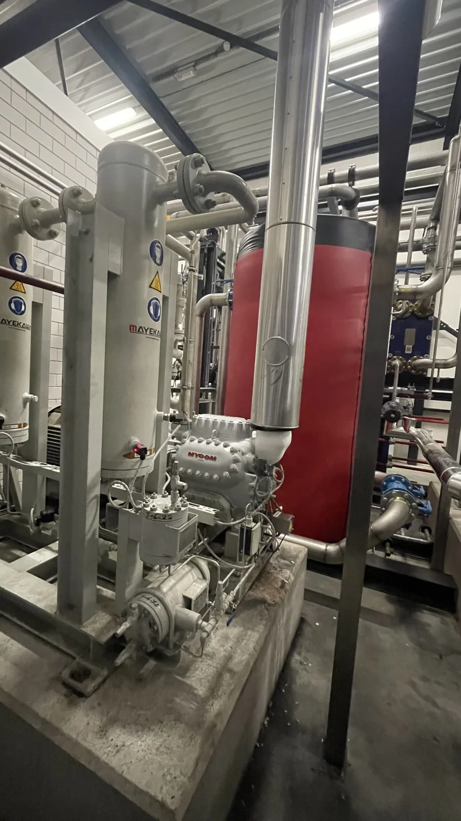 Procesinstallatie met leidingwerk en tank in een bedrijfshal