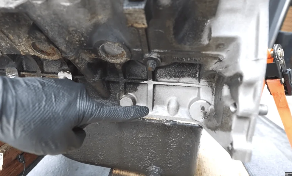 Hand met handschoen bij een deels gereinigd machineonderdeel